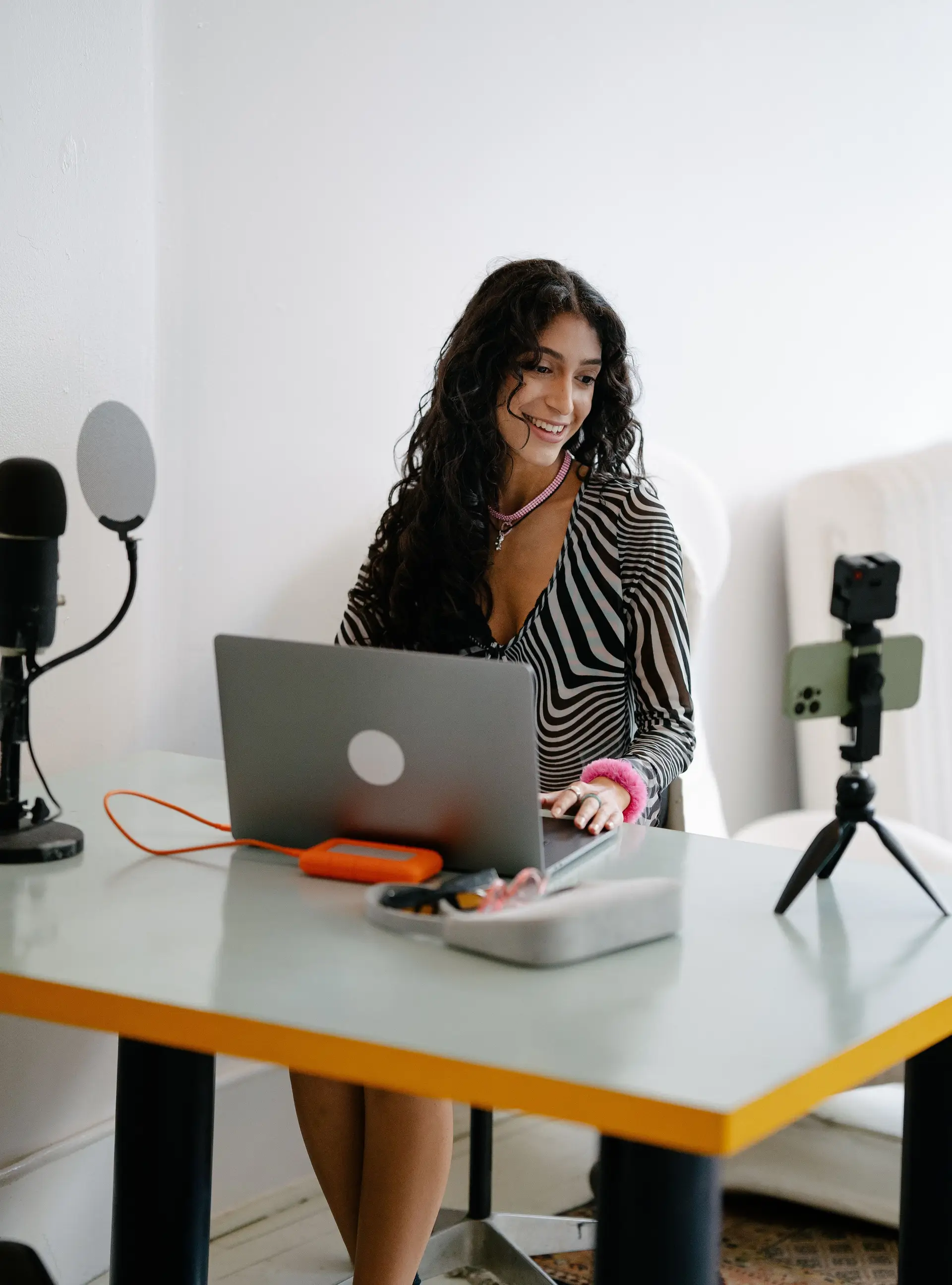 Creatorin arbeitet konzentriert am Laptop im modernen Studio-Workspace