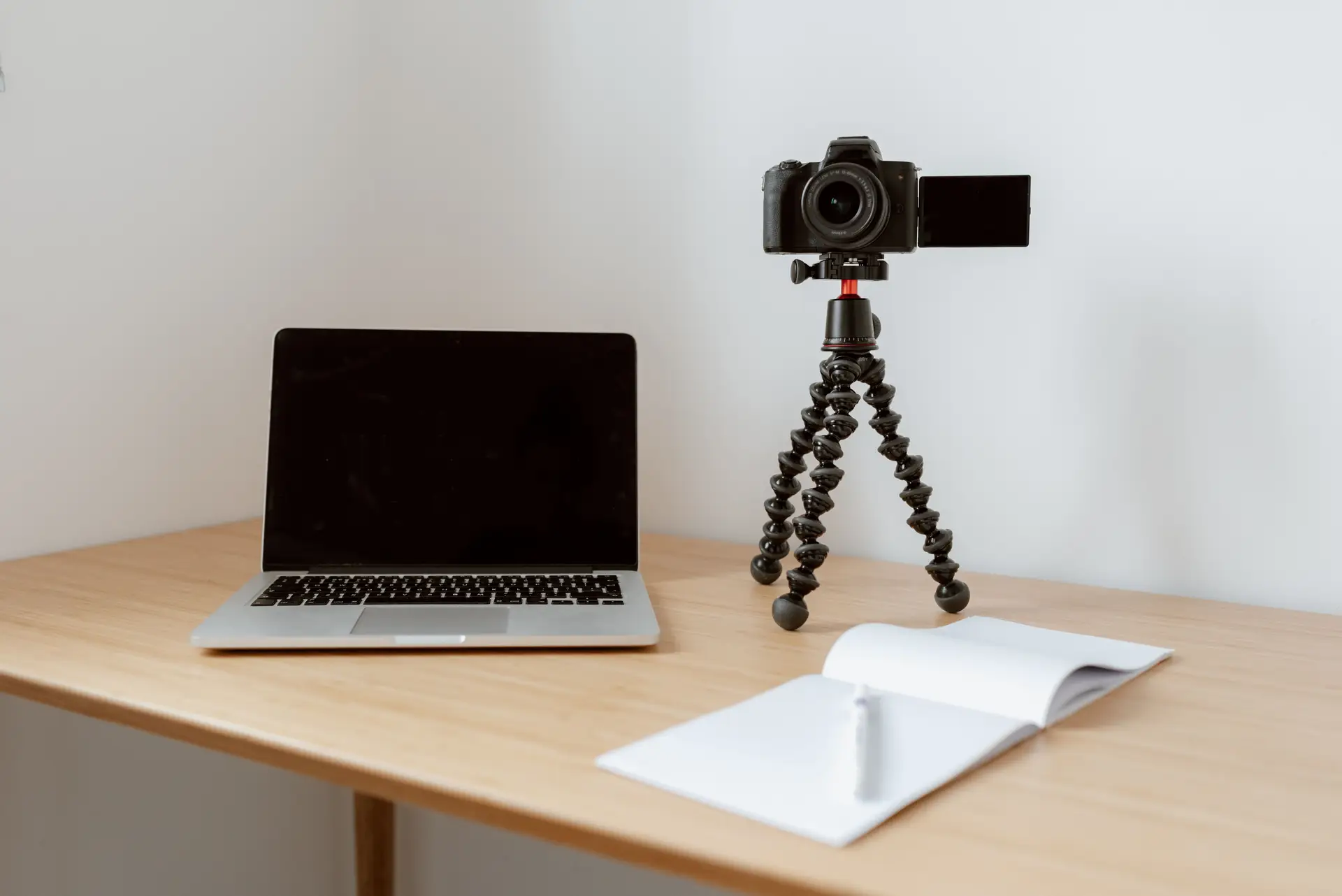 Laptop und Notizbuch auf Holztisch für Blog-Erstellung