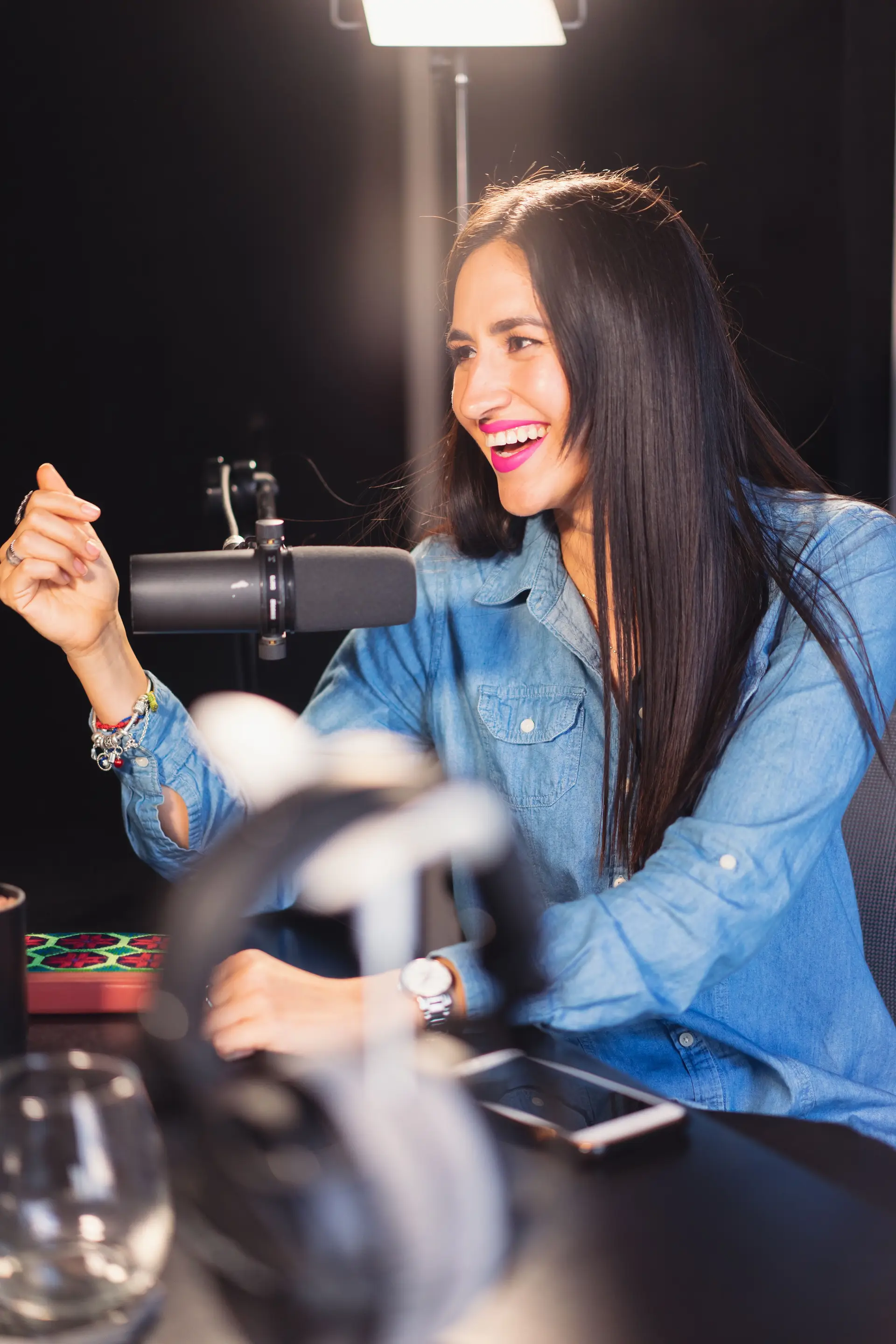 Creatorin lacht im Studio vor Mikrofon